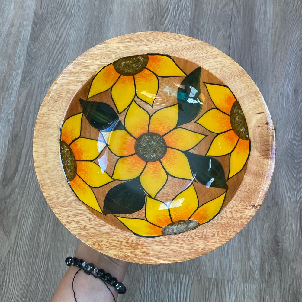 Vintage handcrafted wooden bowl with sunflowers .